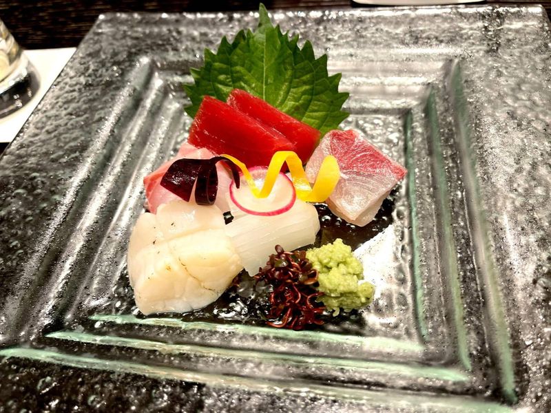 A delicate sashimi plate with shiso leaf and fresh wasabi