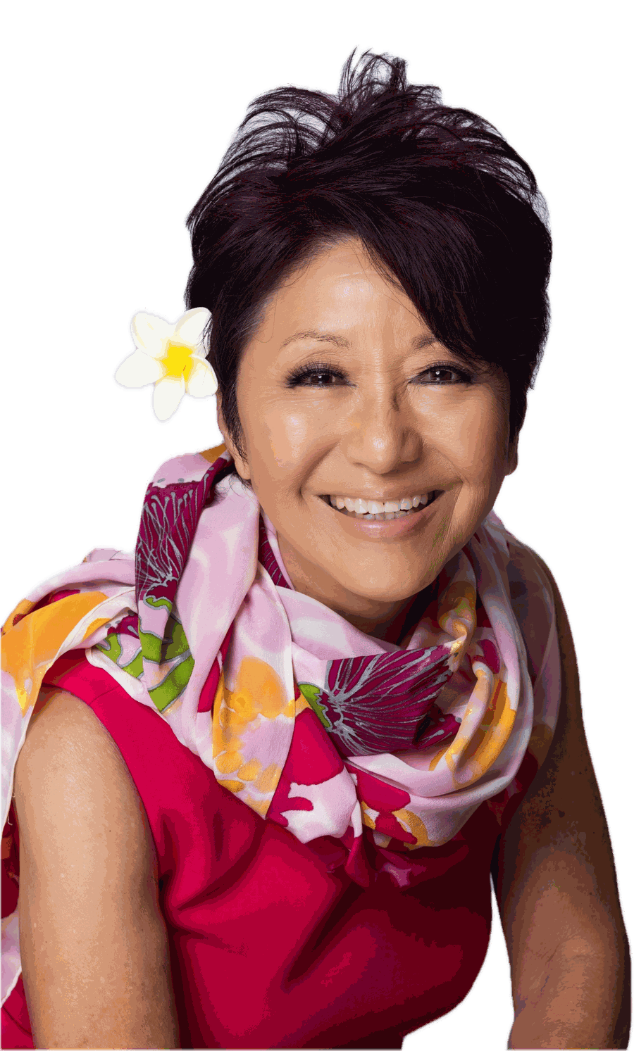 Olelo paʻa Ogawa smiling, wearing a pink floral scarf and a plumeria flower